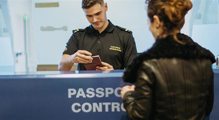 Photo of women having passport checked by customs officer